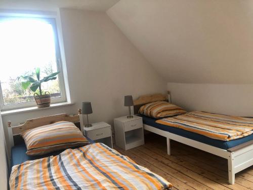 a bedroom with two beds and a window at Hof KuMa in Uelzen