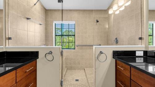 a bathroom with a shower with a glass door at Deluxe Townhome - 5 min to Disney World in Orlando