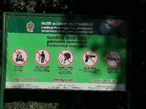a green sign with prohibiting signs on it at The Jungle Life Homestay Thangamalay Sanctuary Haputale by Gisela Sivam in Haputale