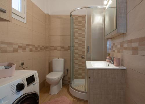 a bathroom with a toilet a sink and a shower at Lakis House Nikiti in Nikiti