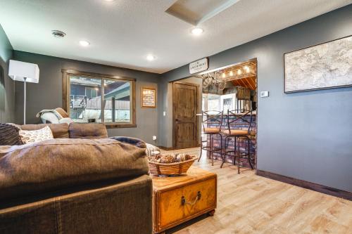 uma sala de estar com um sofá e uma mesa em Stylish Lakefront Cabin in Zimmerman with Hot Tub! 
