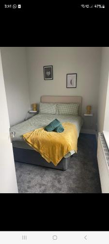 a bedroom with a bed with a yellow blanket at KKB accomodation in Moville