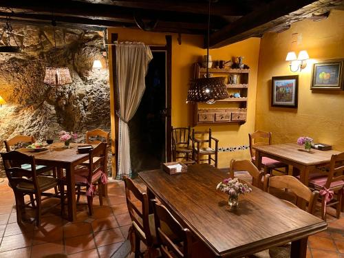 comedor con mesas y sillas de madera en Posada la Trebede, en Perrozo