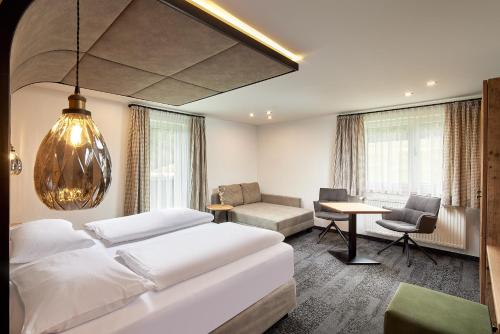 Schlafzimmer mit einem Bett, einem Schreibtisch und einem Stuhl in der Unterkunft Hotel Gasthof Siggen in Neukirchen am Großvenediger