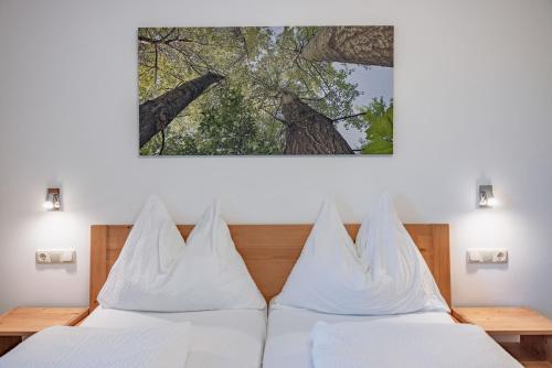 una camera con 2 letti con cuscini bianchi di Bauernhof Pension Hofmayer a Sankt Kanzian