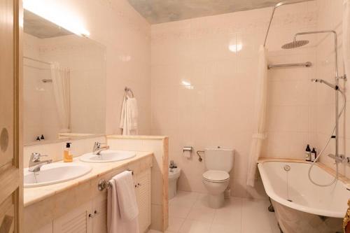 a bathroom with two sinks and a tub and a toilet at Casa Victor Riu in Piera