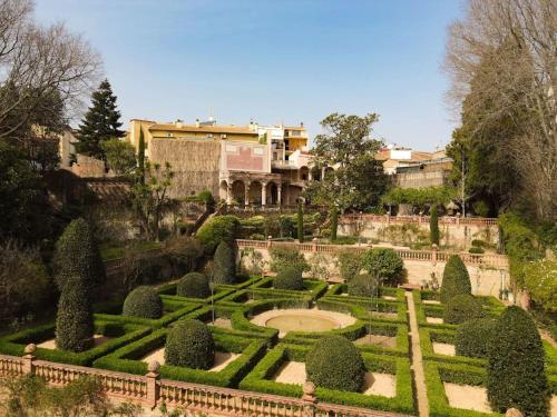 a garden with hedges and a building in the background at Casa Victor Riu in Piera