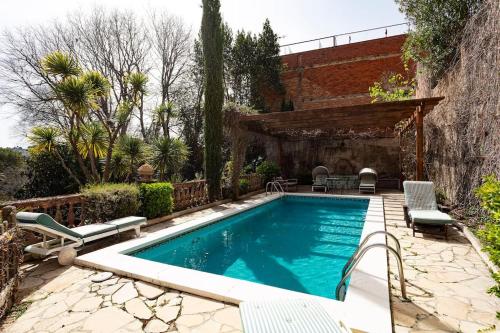 a swimming pool in a yard with chairs and a house at Casa Victor Riu in Piera