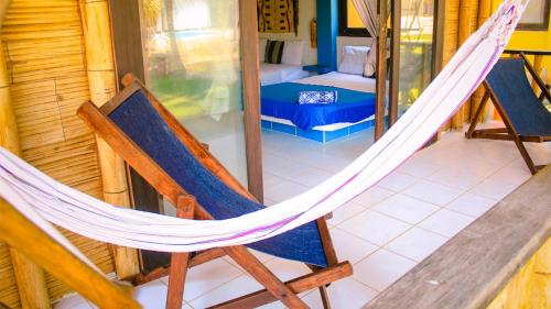 a hammock in a room with a bedroom at Punta Pacífico Bungalows Máncora in Máncora