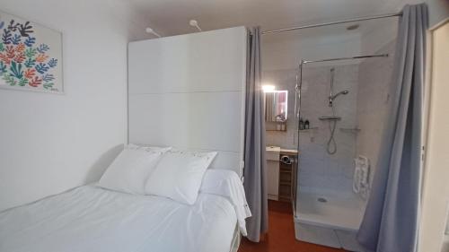 sypialnia z białym łóżkiem i prysznicem w obiekcie LES IRIS w mieście Gourdon