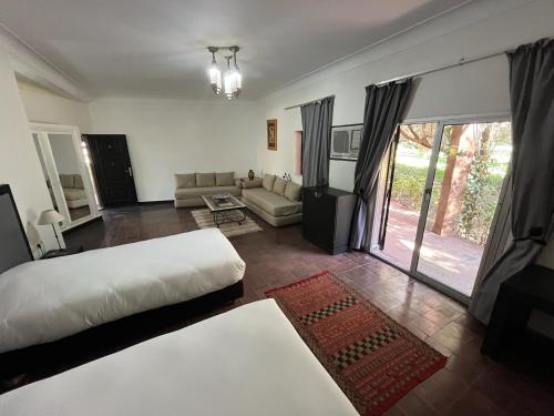 - un salon avec un lit et un canapé dans l'établissement Hotel L'Oliveraie Jnane Zitoune, à Marrakech