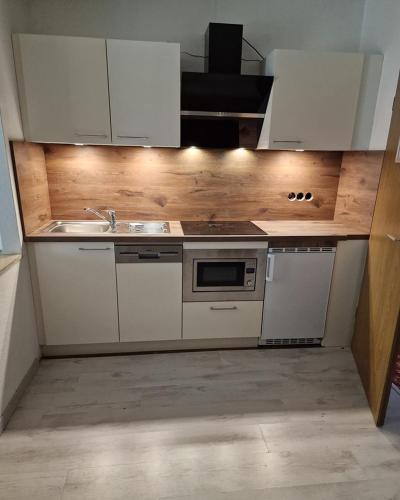 a kitchen with white cabinets and a sink at Landhotel Neding in Hauenstein