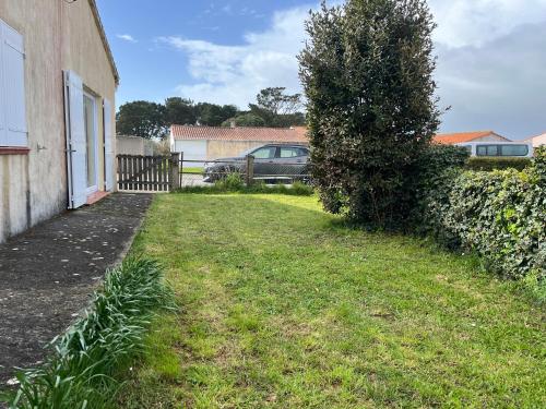 a yard with a car parked next to a fence at Maison Brem-Sur-Mer in Brem-sur-Mer