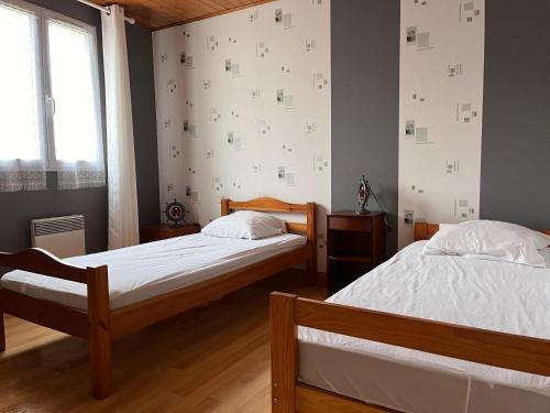 a bedroom with two beds and a window at Maison Brem-Sur-Mer in Brem-sur-Mer