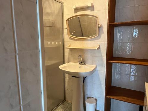 a bathroom with a sink and a shower with a mirror at Maison Brem-Sur-Mer in Brem-sur-Mer