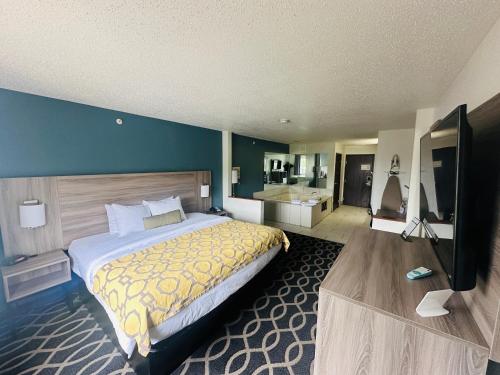 a bedroom with a large bed and a flat screen tv at Baymont by Wyndham Piqua in Piqua