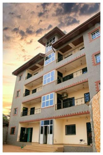 a large apartment building with a sunset in the background at Résidences K and D CAMOCO in Bafoussam