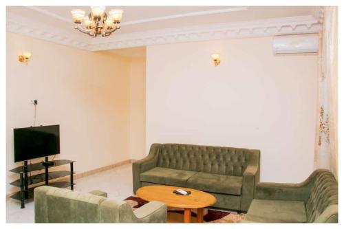 ein Wohnzimmer mit einem Sofa und einem Tisch in der Unterkunft Résidences K and D CAMOCO in Bafoussam