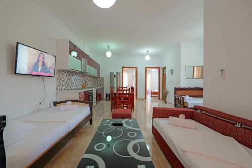 a room with two beds and a living room at Guest House Moonlight in Ksamil