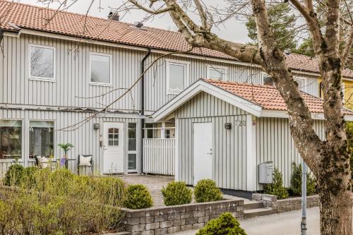 a white house with a red roof at Cozy townhouse 7 beds in Stockholm County in Kungsängen