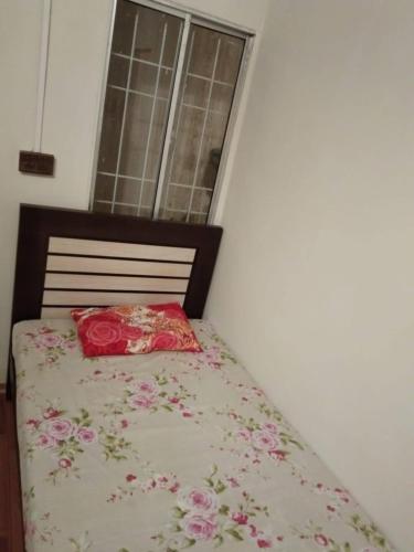 uma cama com uma colcha com flores em H.Y Boys Hostel & Rooms for Rent em Karachi