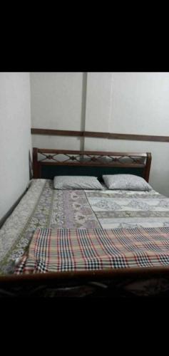 a bed with two pillows on it in a room at H.Y Boys Hostel & Rooms for Rent in Karachi