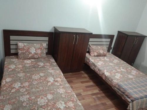 2 letti posti uno accanto all'altro in una stanza di H.Y Boys Hostel & Rooms for Rent a Karachi