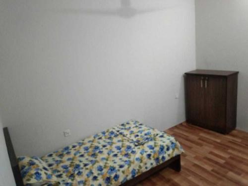 a small bedroom with a bed and a dresser at H.Y Boys Hostel & Rooms for Rent in Karachi