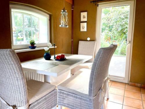ein Esszimmer mit einem weißen Tisch und Stühlen in der Unterkunft idyllisch gelegenes Ferienhaus nähe Heiligenhafen in Gremersdorf