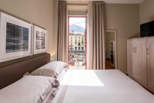 a bedroom with two beds and a large window at Hotel Centrale in Cernobbio
