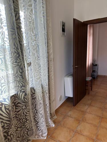 a room with a curtain and a door with a tile floor at Casa Rosa in Elice
