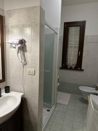 a bathroom with a shower and a phone on the wall at Casa Rosa in Elice