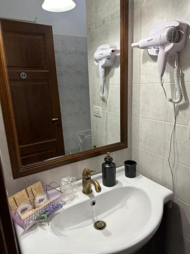 a bathroom sink with a hair dryer and a mirror at Casa Rosa in Elice