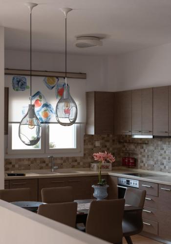 a kitchen with two lights and a table with chairs at Lakis House Nikiti in Nikiti