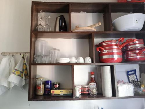 a wooden shelf with dishes and other items on it at Kai Suites Kitale in Kitale