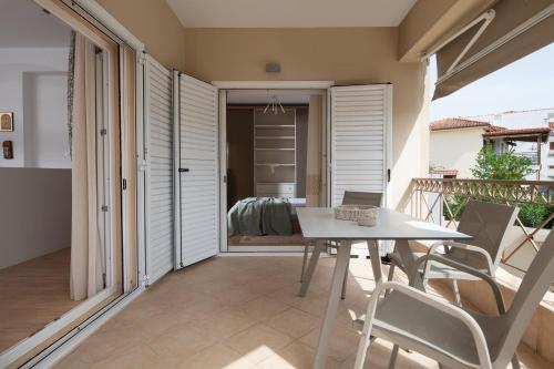 a dining room with a table and chairs on a balcony at Lakis House Nikiti in Nikiti