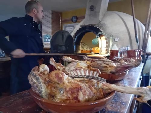 a man is preparing a thanksgiving turkey in a pan at Casa Rural Inma in Muñoveros