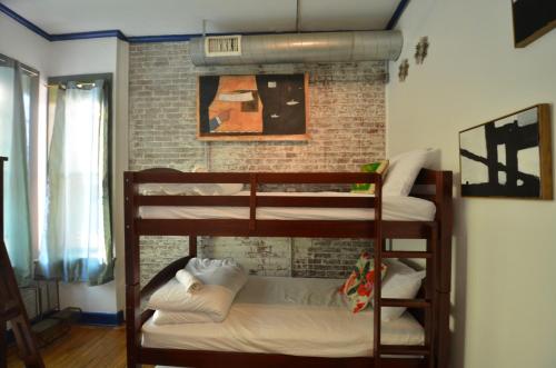 two bunk beds in a room with a brick wall at Michie Hostel in Providence