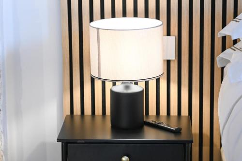 a lamp on a table next to a bed at DIMORA BIANCA in Triggianello