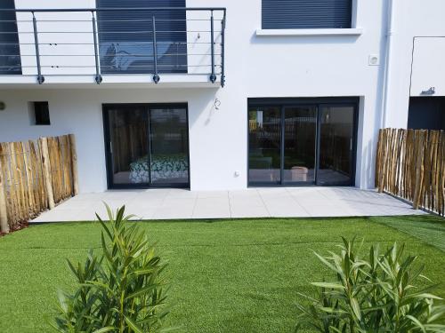 Biały dom z trawnikiem przed nim w obiekcie 500 m de la plage - Terrasse - 3 chambres w mieście Piriac-sur-Mer