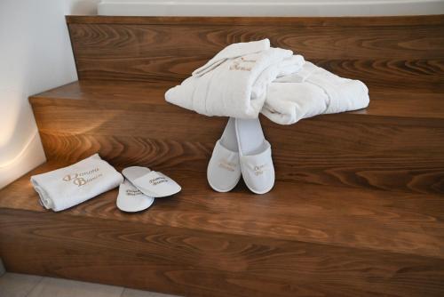 a pile of towels and slippers on the stairs of a bathroom at DIMORA BIANCA in Triggianello