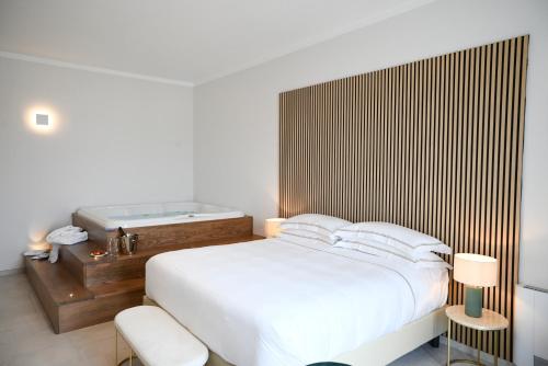 a bedroom with a bed and a bath tub at DIMORA BIANCA in Triggianello