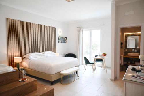 a bedroom with a bed and a table and chairs at DIMORA BIANCA in Triggianello