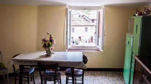 cocina con mesa con sillas y ventana en appartamento x 6 persone, en Monasterolo del Castello