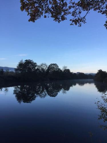 a view of a lake with trees in the background at Mountain views in the heart of Brecon Town in Brecon