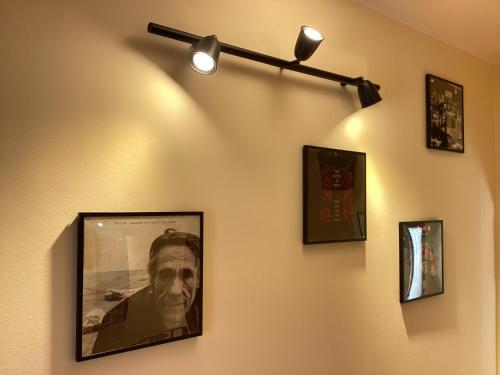 a wall with pictures and lights on it at La casa di B in Paganica