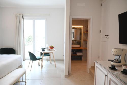a room with a bed and a table and a kitchen at DIMORA BIANCA in Triggianello
