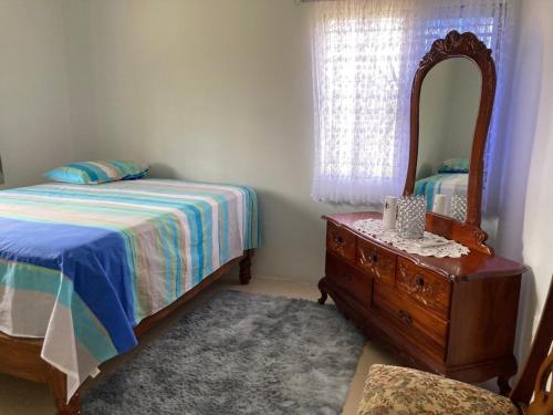 a bedroom with a bed and a mirror and a dresser at Blissful Retreat in Gravel Hill 
