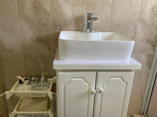 a bathroom with a sink and a white cabinet at 1 Bedroom Blissful Retreat - A C & Private Garden in Gravel Hill