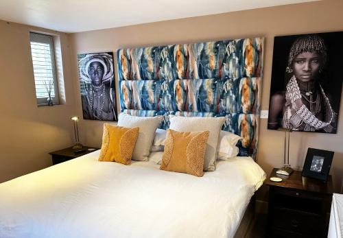 a bedroom with a king sized bed with a large headboard at The Red Lion in Blewbury